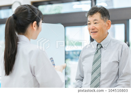 到藥店諮詢藥劑師/配藥師的中老年男性（用藥指導） 104510803