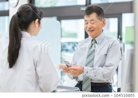 到藥店諮詢藥劑師/配藥師的中老年男性（用藥指導） 104510805