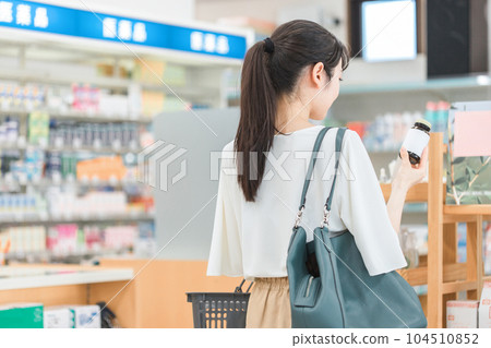 A woman shopping at a pharmacy, drug store, or convenience store A woman shopping at a pharmacy, drug store, or convenience store 104510852