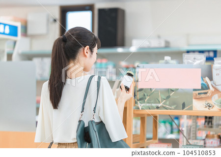 A woman shopping at a pharmacy, drug store, or convenience store A woman shopping at a pharmacy, drug store, or convenience store 104510853