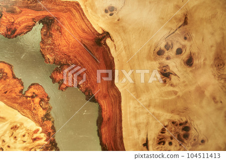 The background is made of wood and transparent epoxy resin in the middle with space for copying. Wooden table covered with epoxy resin. High quality photo 104511413