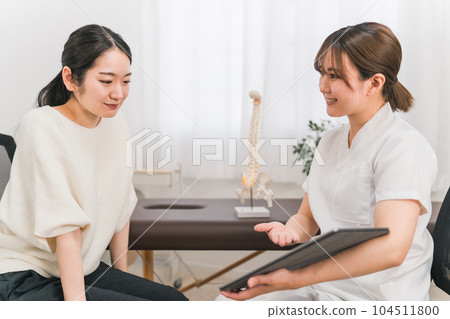 在骨科診所/骨科診所擔任物理治療師、按摩師和解釋計劃、檢查、諮詢和諮詢的治療師的女性 在骨科診所/骨科診所擔任物理治療師、按摩師和解釋計劃、檢查、諮詢和諮詢的治療師的女性 104511800