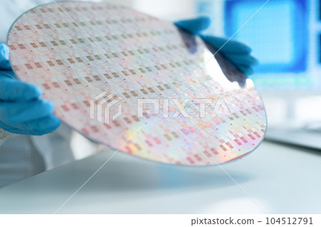 Engineer inspecting wafers in clean room 104512791