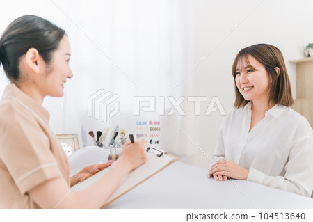 A manicurist and a customer's woman having a hearing at a nail salon A manicurist and a customer's woman having a hearing at a nail salon 104513640