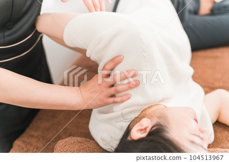 Asian woman masseuse, chiropractor, therapist, chiropractor, physiotherapist giving shoulder massage 104513967