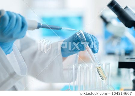 穿著實驗室外套的研究人員用吸管和試管進行研究和開發 穿著實驗室外套的研究人員用吸管和試管進行研究和開發 104514607
