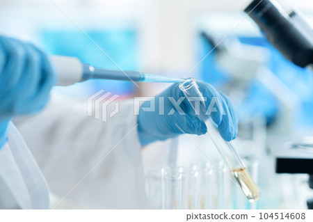 穿著實驗室外套的研究人員用吸管和試管進行研究和開發 穿著實驗室外套的研究人員用吸管和試管進行研究和開發 104514608