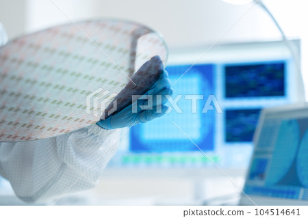 Engineer inspecting wafers in clean room 104514641
