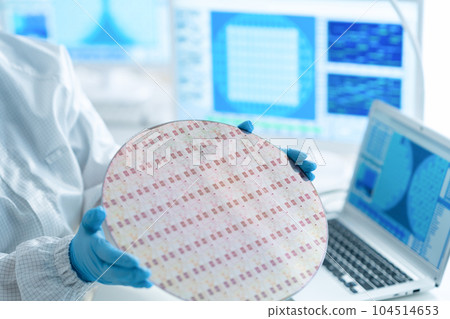 Engineer inspecting wafers in clean room Engineer inspecting wafers in clean room 104514653
