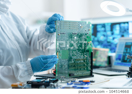 工程師在潔淨室中檢查電路板 104514668