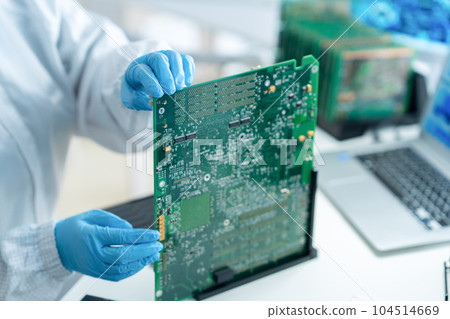 Engineer inspecting a board in a clean room 104514669