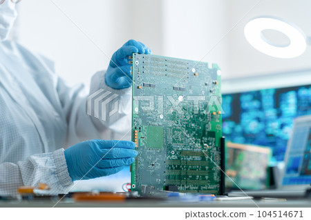 Engineer inspecting a board in a clean room 104514671