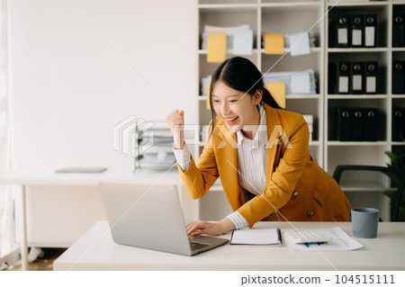 Asian business woman are delighted and happy with the work they do on their tablet, laptop and taking notes at the office.. 104515111