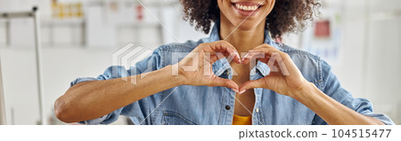 Smiling African-American fashion designer in denim shirt shows h 104515477