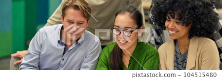Group of happy multiracial business people sitting at desk in the modern coworking space, looking at laptop screen and smiling, working together Group of happy multiracial business people sitting at desk in the modern coworking space, looking at laptop screen and smiling, working together 104515480