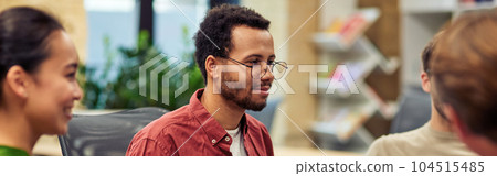 Young mixed race man looking attentively at colleague while having brainstorming meeting in the modern office Young mixed race man looking attentively at colleague while having brainstorming meeting in the modern office 104515485