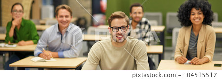 Business lecture. Group of happy multiracial people sitting in the modern office and listening to coach or speaker during seminar, selective focus on cheerful caucasian man Business lecture. Group of happy multiracial people sitting in the modern office and listening to coach or speaker during seminar, selective focus on cheerful caucasian man 104515517