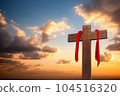 Wooden cross with red cloth wrapped around on sunset sky background 104516320