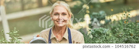 Middle aged caucasian business woman watering plants 104516762
