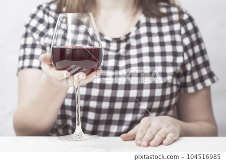A woman with glass red wine. A woman is drinking red wine A woman with glass red wine. A woman is drinking red wine 104516985
