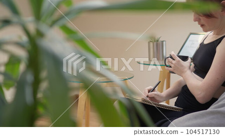 A woman immerses herself in her notes, ensuring clarity of her thoughts and plans, which contributes to her development and success. 104517130