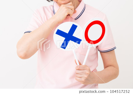 A middle-aged caregiver wearing a polo shirt who is worried about holding a roundness plate 104517252