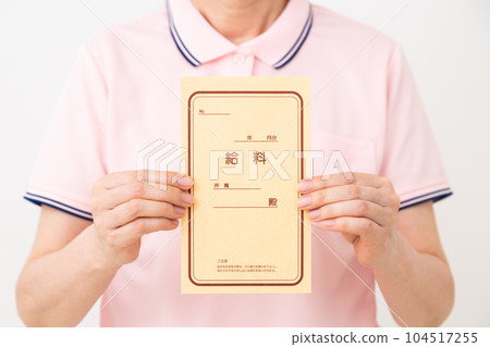 一名穿著馬球衫的中年護理人員拿著工資袋 一名穿著馬球衫的中年護理人員拿著工資袋 104517255