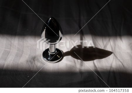 Steel anal plug on a white sheet. Steel anal plug on a white sheet. 104517358