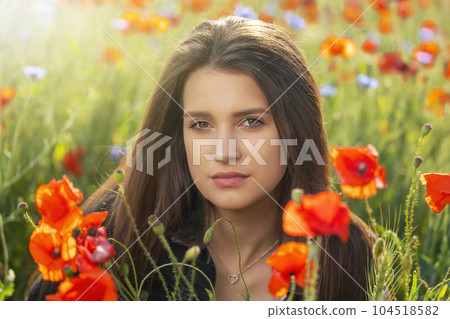 Portrait of beautiful girl posing in red poppies  meadow. 104518582