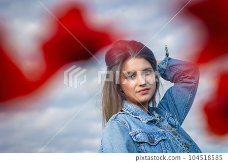Portrait of attractive long haired girl from behind red poppy leaves. Portrait of attractive long haired girl from behind red poppy leaves. 104518585