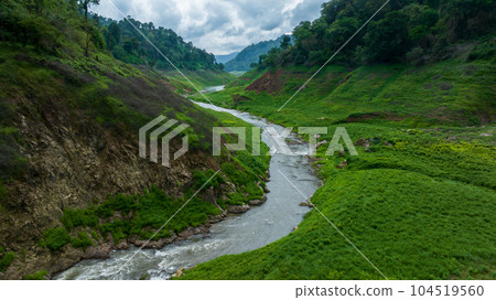 Aerial view tropical green forest and river with mountains in background, Green tree forest view from above river and forest. 104519560