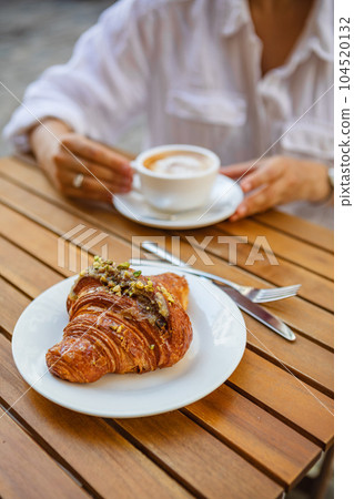 Breakfast with crunchy croissants and coffee on a terrace in the summer Breakfast with crunchy croissants and coffee on a terrace in the summer 104520132