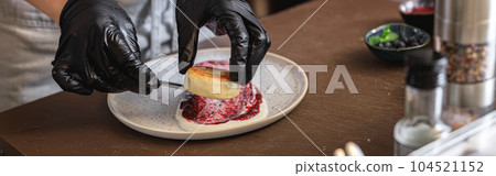 Professional kitchen worker in uniform decorated ready cheesecakes for breakfast in restaurant Professional kitchen worker in uniform decorated ready cheesecakes for breakfast in restaurant 104521152