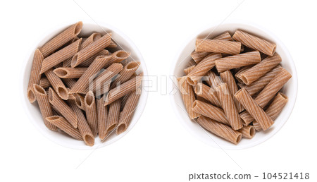Buckwheat penne and tortiglioni, gluten free whole grain pasta, in white bowls. Brown noodles, made of pure buckwheat semolina, extruded into cylinder-shaped pieces, with ridges to take on more sauce. 104521418