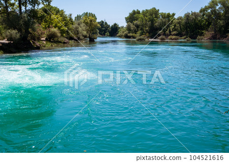 Manavgat waterfall Manavgat River is near the city of Side, 3 km north of Manavgat in Turkey. A wide stream of water falls from a low height. 104521616