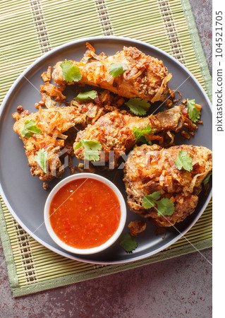 Thai Southern Fried Chicken with crispy shallots and sweet chili sauce close-up on a plate. Vertical top view 104521705