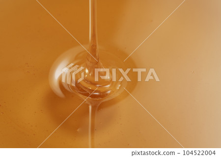 Closeup shot of organic honey pouring in bowl Closeup shot of organic honey pouring in bowl 104522004