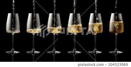 Pouring white wine into a glass on a black background. Pouring white wine into a glass on a black background. 104523069