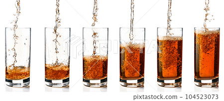 Pouring drink into a glass on a white background. Pouring drink into a glass on a white background. 104523073