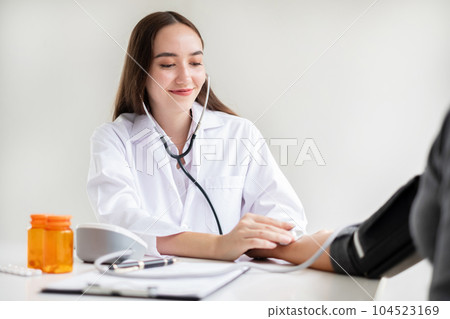 The female doctor measured blood pressure, the patient examined the heartbeat and sat down to talk about health care closely. health care concept 104523169