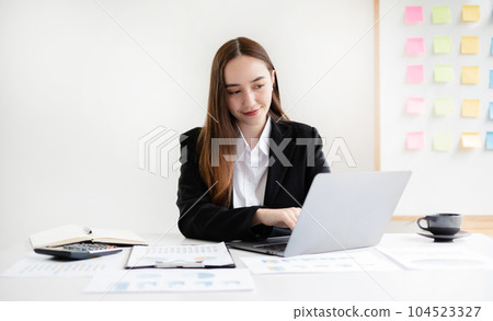 businesswomen sit at their desks and calculate financial graphs showing results about their investments, planning successful business growth processes in the office 104523327