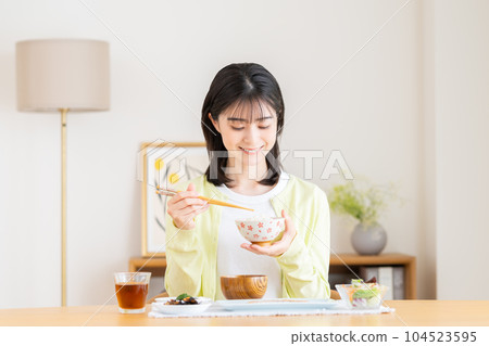 Young woman eating breakfast Young woman eating breakfast 104523595