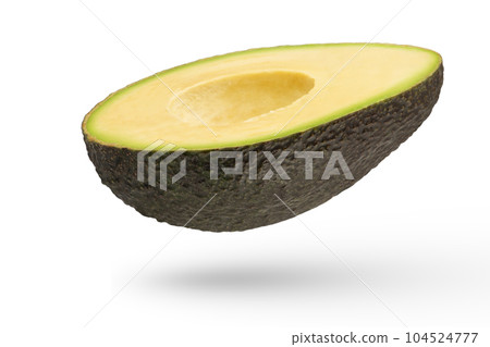 Flying fruits. Half of an avocado on a white isolated background. Avocado with pitted crust inside casting a shadow. Seedless avocado isolate. To insert into a project. 104524777