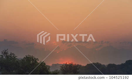 The red sun rises over the city. Dawn and orange sky copy space The red sun rises over the city. Dawn and orange sky copy space 104525192