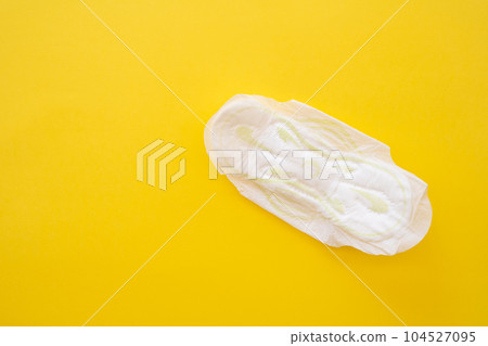 Women's sanitary napkin on a yellow background close-up. Women's sanitary napkin on a yellow background close-up. 104527095