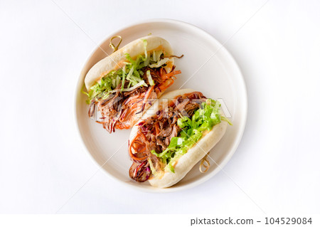 Steamed buns Bao with pulled beef and iceberg lettuce Steamed buns Bao with pulled beef and iceberg lettuce 104529084