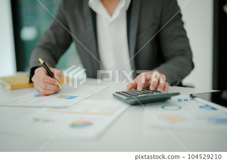 Young asian male work with financial papers at home count on calculator before paying taxes receipts online, planning budget glad to find chance for economy saving money, audit concepts 104529210