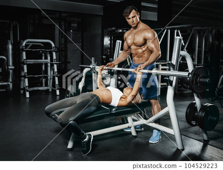 Fitness instructor exercising with his client at the gym. Fitness instructor exercising with his client at the gym. 104529223
