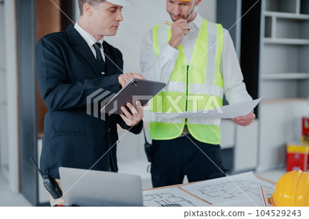 multi ethnic engineer brainstorming and measuring for cost estimating on blueprint and floor plan drawings about design architectural and engineering for houses and buildings. multi ethnic engineer brainstorming and measuring for cost estimating on blueprint and floor plan drawings about design architectural and engineering for houses and buildings. 104529243