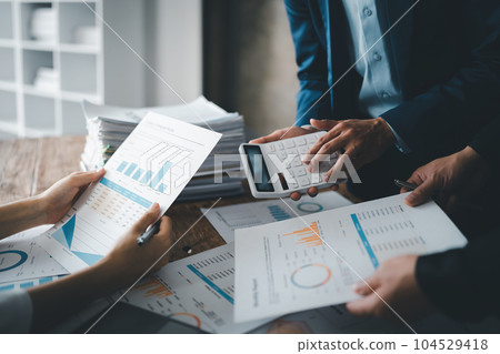 Accountant checking financial statement or counting by calculator income for tax form, Business woman sitting and working with colleague discussing the desk in office. Audit concept. 104529418